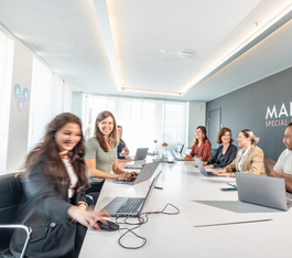 Ein Team aus 7 Personen arbeiten in einem Manor Büro